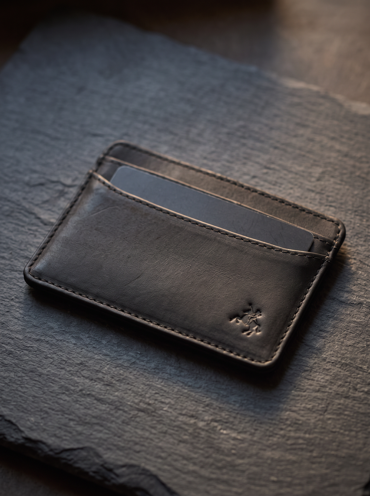 Carlo black card holder on slate with a card partly drawn